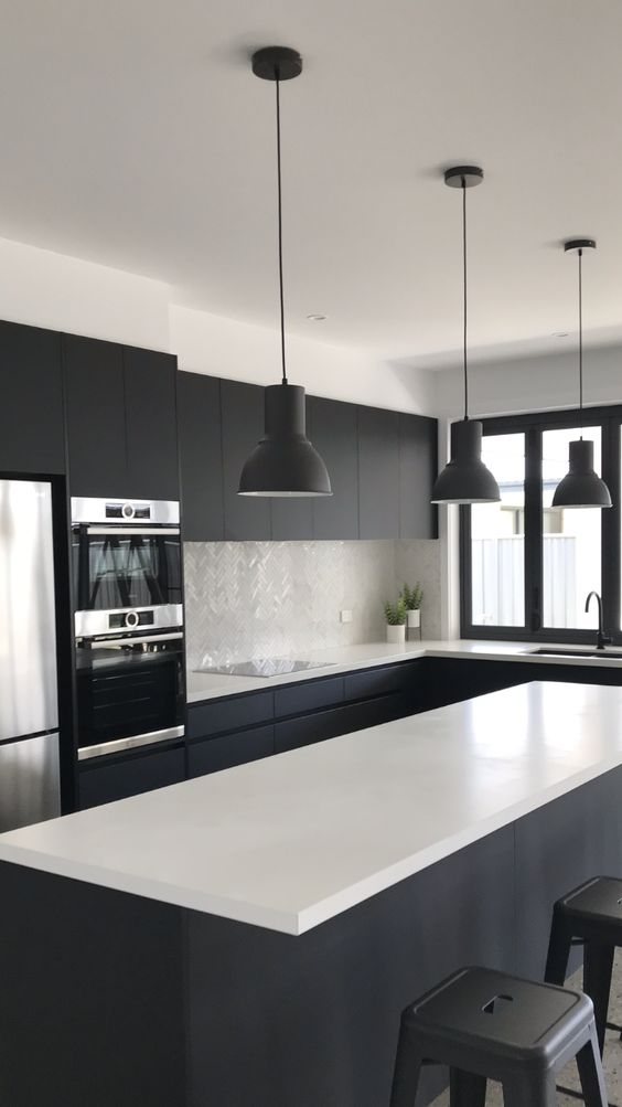 https://www.digsdigs.com/photos/2009/08/a-bold-black-and-white-kitchen-with-matte-cabinets-a-large-kitchen-island-white-coutnertops-and-a-mother-of-pearl-backsplash-black-pendant-lamps.jpg