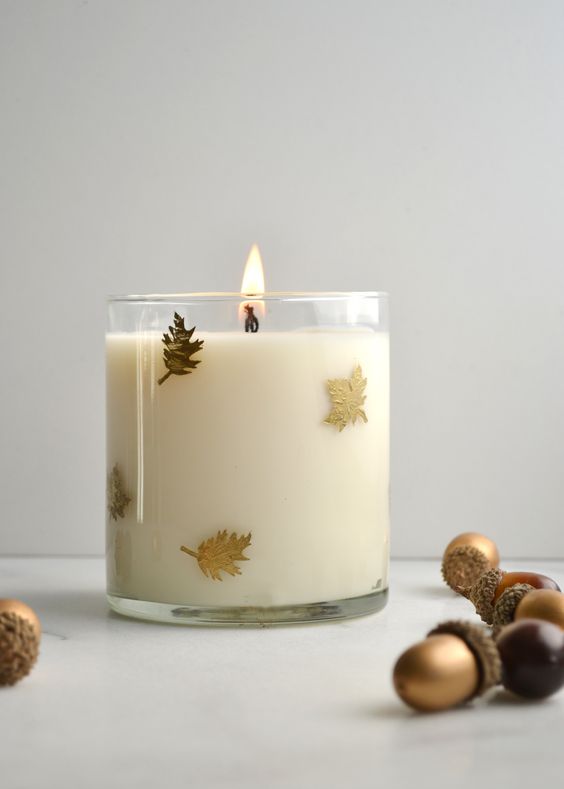 شمعة زجاجية بأوراق ذهبية صغيرة ملحقة بالخارج هي فكرة جميلة عن ديكور عيد الشكر