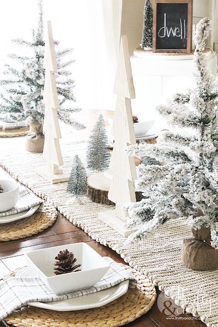 مزرعة طاولات عيد الميلاد مع مفرش مائدة منسوج ومفارش ، وأشجار عيد الميلاد المتدفقة والخشب الرقائقي ، والخزف الأبيض وأكواز الصنوبر