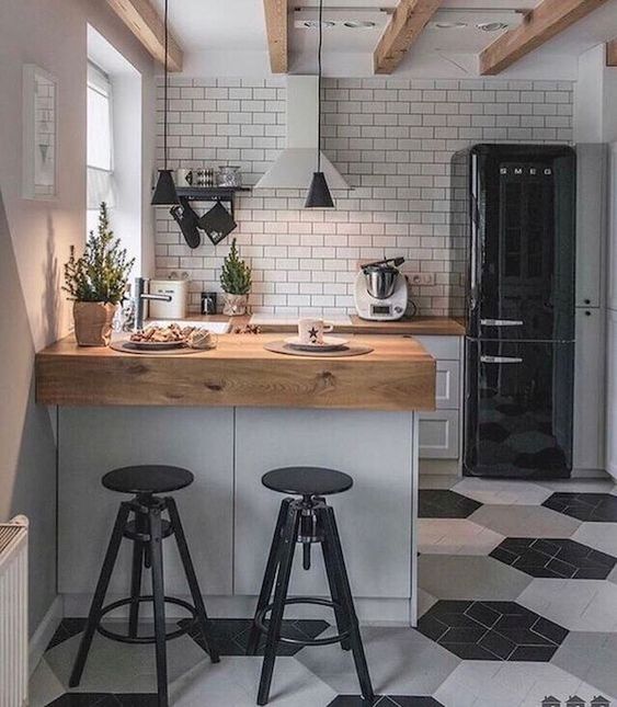 A Small Scandinavian Kitchen In Black White And Grey With Butcherblock Countertops And A White Tile Backsplash And Pendant Lamps 