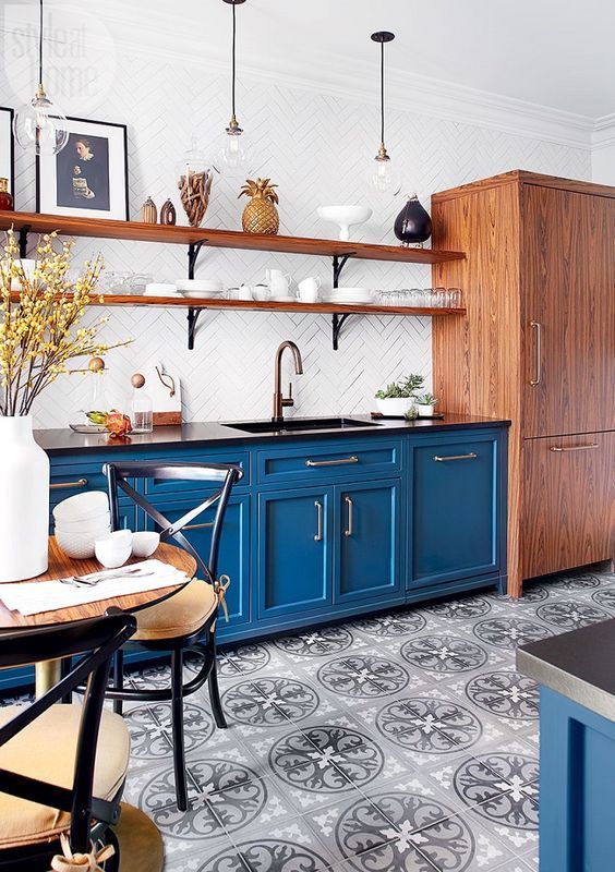 https://www.digsdigs.com/photos/2012/03/a-bold-blue-kitchen-with-a-printed-tile-floor-wooden-shelves-and-a-storage-unit-black-chairs-with-cushions-is-welcoming.jpg