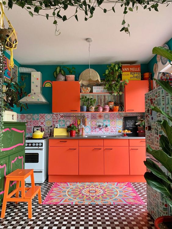 https://www.digsdigs.com/photos/2012/03/a-crazily-colorful-kitchen-with-orange-cabinets-a-colorful-tile-backsplash-a-bold-rug-emerald-walls-and-bold-furniture.jpg