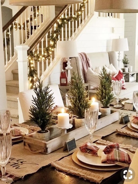 طاولة شتوية منزلية مع عداء من الخيش ومفارش ومناديل منقوشة وأشجار عيد الميلاد الصغيرة والشموع والمناديل المنقوشة