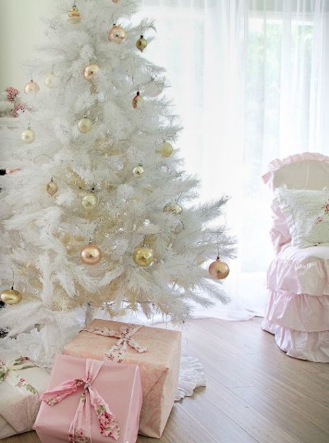 a medium size white Christmas tree with gold and copper ornaments looks glam and shiny