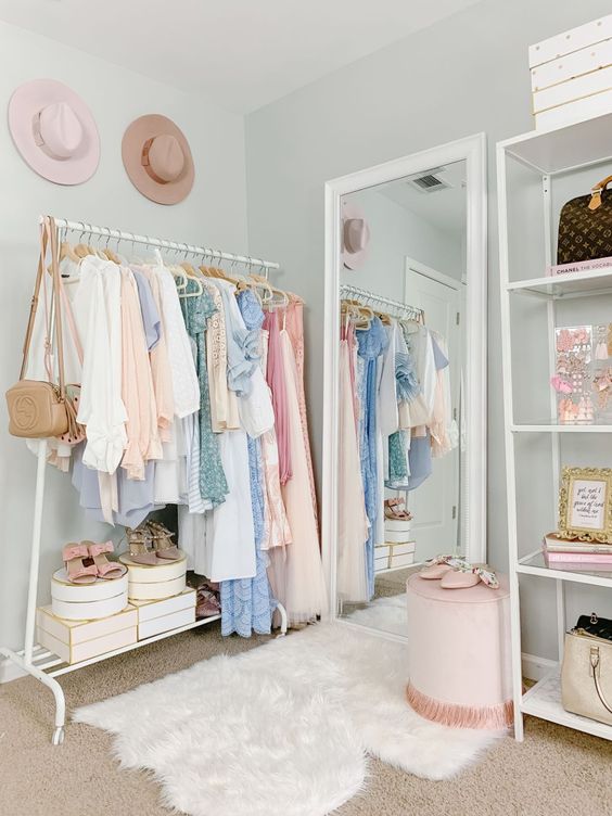 https://www.digsdigs.com/photos/2013/04/a-cute-pastel-closet-with-light-blue-walls-an-open-makeshift-closet-a-large-mirror-layered-rugs-a-pink-stool-and-hats-as-decor.jpg