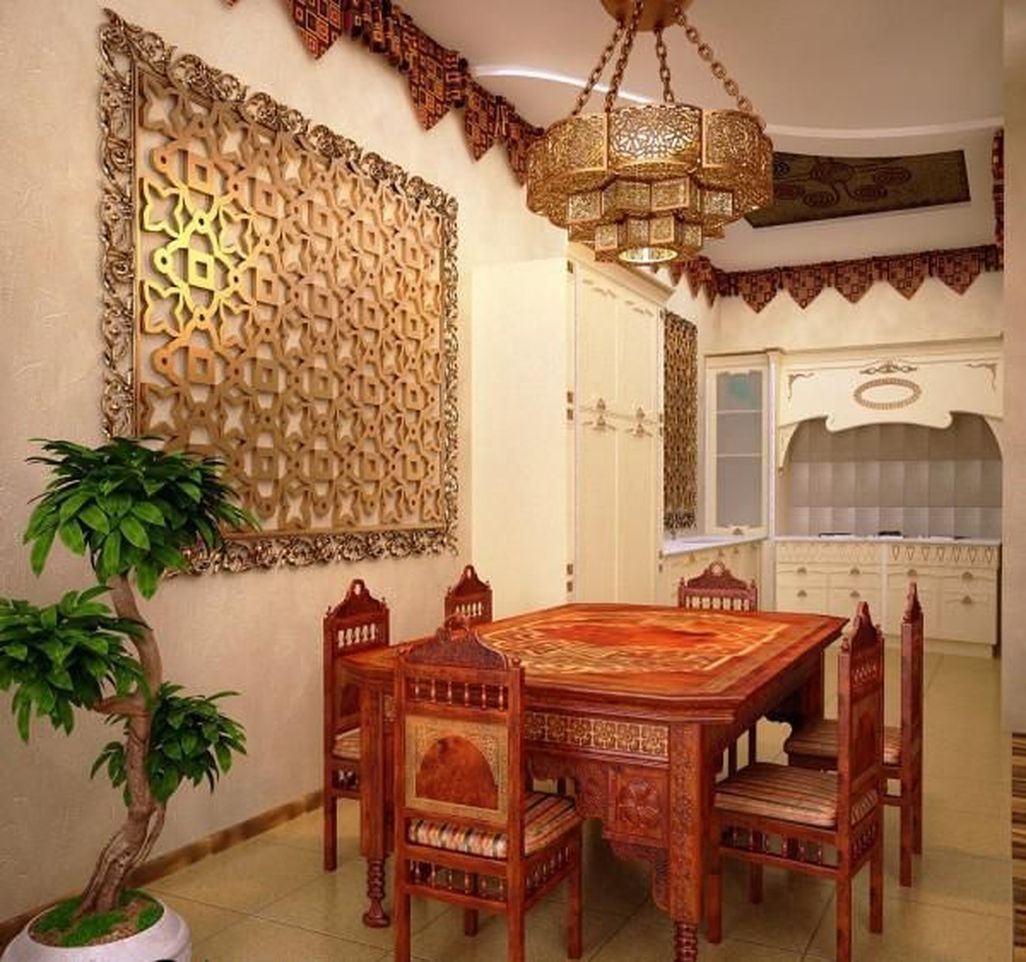 غرفة طعام جميلة مع أثاث مغربي منحوت ثقيل ومصباح معلق معدني جميل وعمل فني مقطوع بالليزر