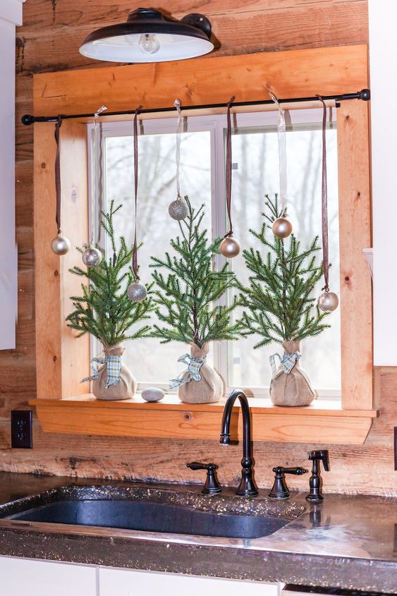 mini Christmas trees in burlap and metallic ornaments on the window for a holiday feel in the space