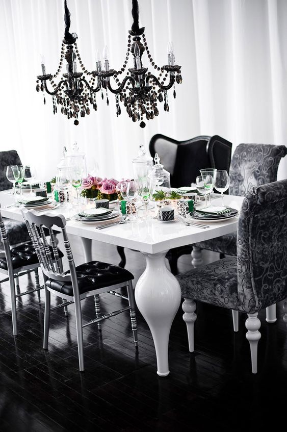 https://www.digsdigs.com/photos/2014/02/a-catchy-Gothic-dining-space-with-a-white-table-with-unique-legs-black-chairs-and-armchairs-black-crystal-chandeliers-over-the-table.jpg