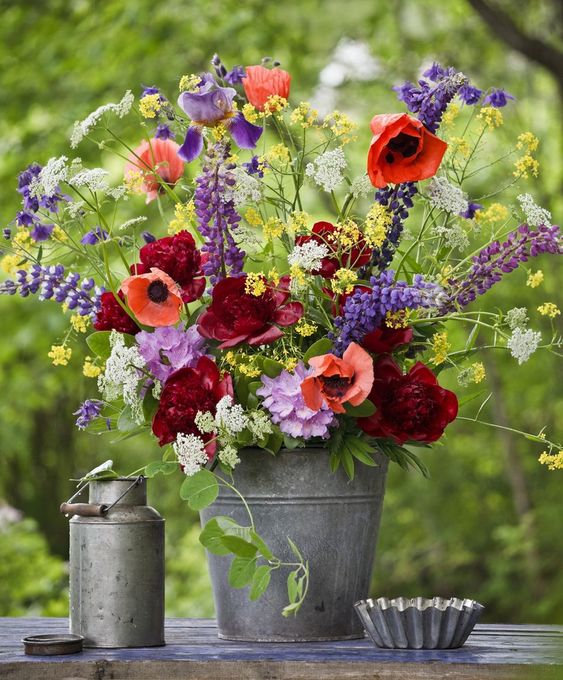 ضع تنسيق الأزهار الملونة في دلو معدني بسيط لجعل ديكورك الصيفي مشرقًا وممتعًا