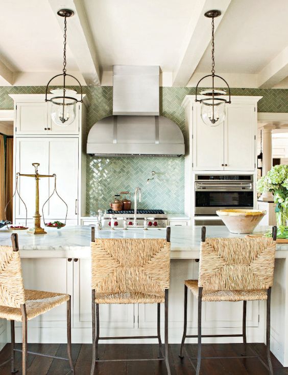 https://www.digsdigs.com/photos/2014/07/a-beautiful-coastal-kitchen-with-white-vintage-cabinets-a-large-kitchen-island-with-wicker-chairs-glass-pendant-lamps-and-a-green-tile-backsplash.jpg