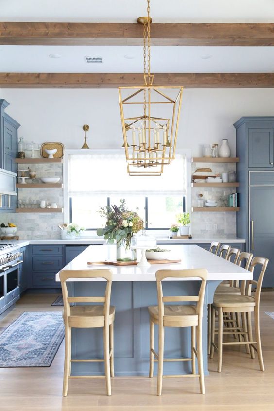 https://www.digsdigs.com/photos/2014/07/a-coastal-farmhouse-kitchen-with-classic-blue-cabinetry-and-a-kitchen-island-wooden-stools-beams-and-shelving-and-touches-of-gold.jpg