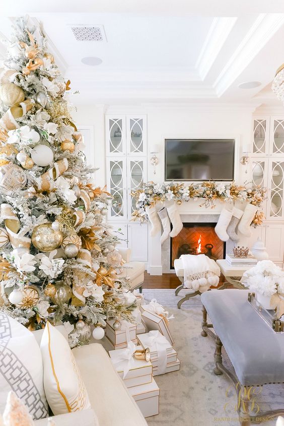 شجرة عيد الميلاد براقة ولامعة مزينة بأزهار بيضاء مزيفة وشرائط ذهبية وبيضاء وزخارف وأوراق