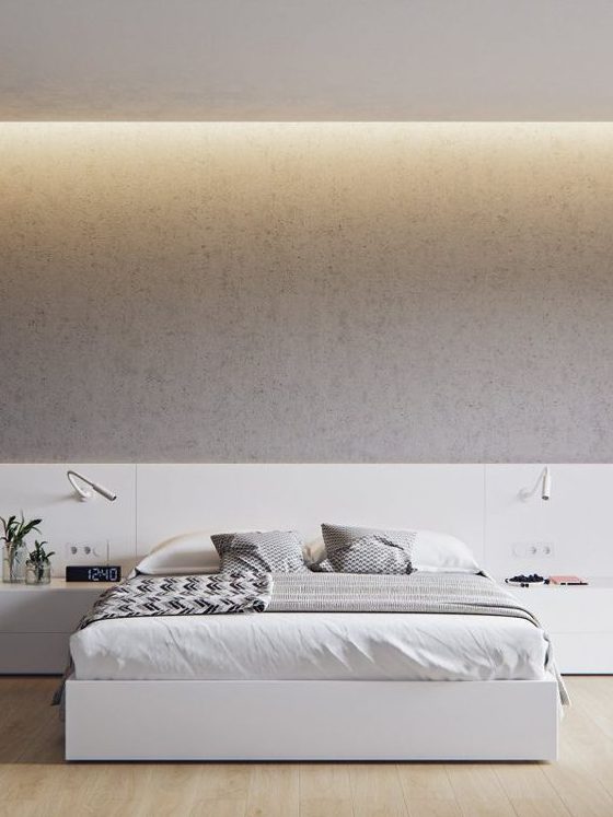 غرفة نوم أنيقة بسيطة مع سرير أبيض وطاولات جانبية بالإضافة إلى ألواح على الحائط وأضواء مدمجة وشمعدانات مريحة