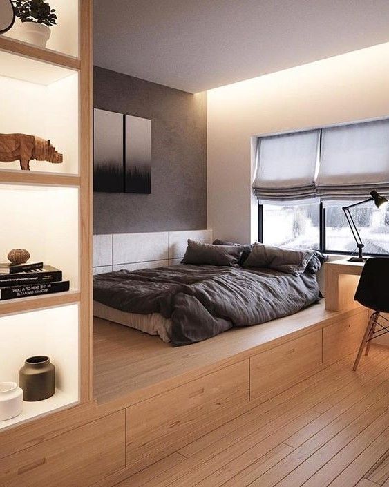 غرفة نوم بسيطة مع سرير منصة مع تخزين ومنافذ مضاءة للتخزين ومكتب مدمج وكرسي أسود