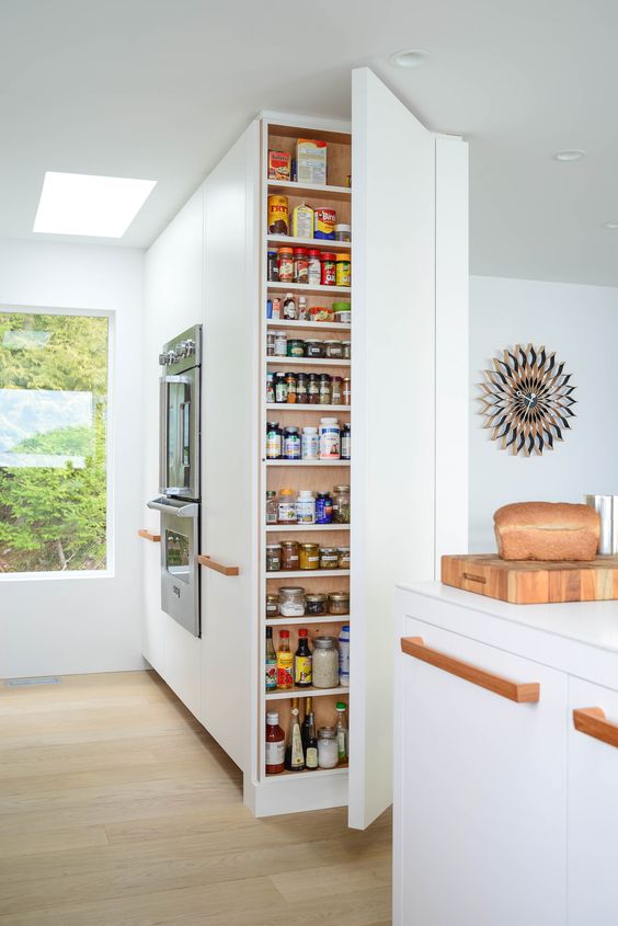https://www.digsdigs.com/photos/2015/05/a-very-narrow-and-tall-storage-unit-with-lots-of-shelves-lets-you-store-a-lot-of-stuff-hidden-and-the-kitchen-looks-sleek.jpg