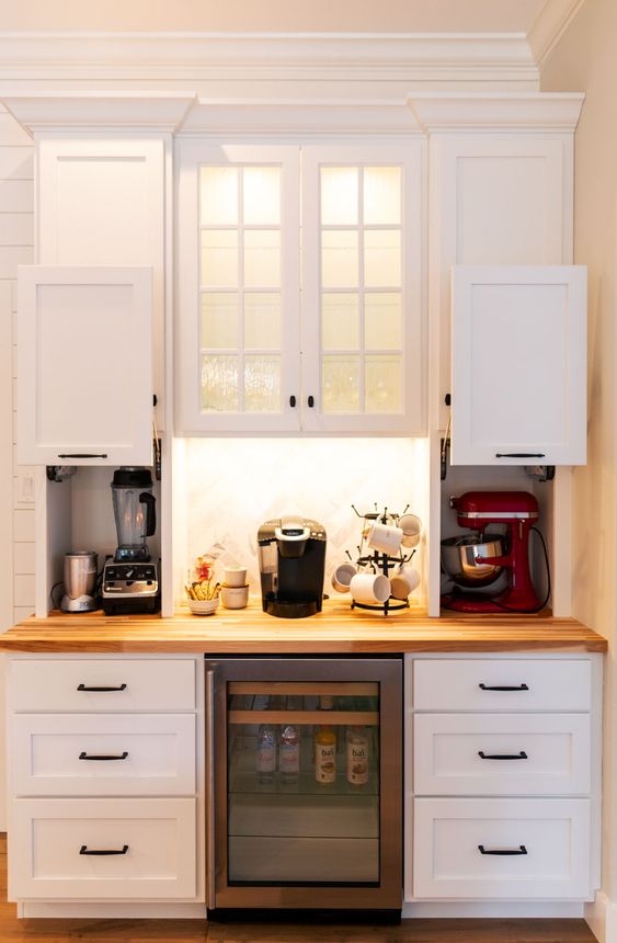 https://www.digsdigs.com/photos/2015/05/mini-cabinets-with-sliding-doors-and-with-appliances-hidden-there-plus-a-coffee-station-in-the-center-is-a-stylish-idea.jpg
