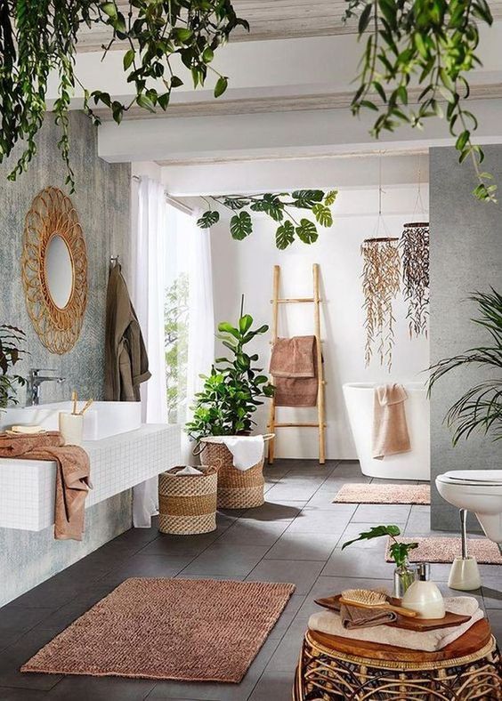 https://www.digsdigs.com/photos/2015/06/a-boho-spa-bathroom-with-a-floating-vanity-an-oval-tub-a-rattan-stool-a-pink-rug-and-towels-lots-of-potted-greenery-and-greenery-chandeliers.jpg