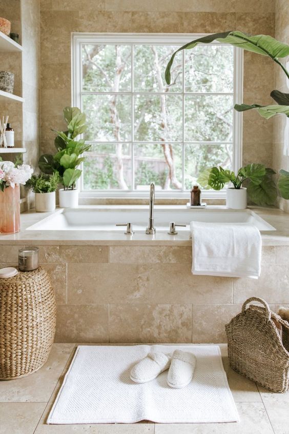 https://www.digsdigs.com/photos/2015/06/a-gorgeous-neutral-spa-bathroom-clad-with-limestone-tiles-with-a-tub-clad-with-them-built-in-shelves-and-potted-greenery-a-woven-pouf-and-a-bag.jpg