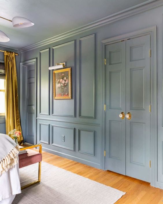 غرفة زرقاء فاتحة مع قولبة على الجدران والأبواب ، مع لمسات من الذهب والخردل وكرسي بنفسجي جميل