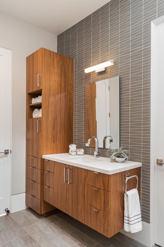 https://www.digsdigs.com/photos/2016/02/a-chic-mid-century-modern-bathroom-with-catchy-grey-tiles-stained-wooden-furniture-a-mirror-with-a-lamp-over-it.jpg