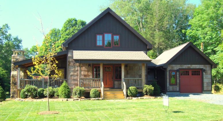 a rustic style house with a dutch gable roof and a neat front yard