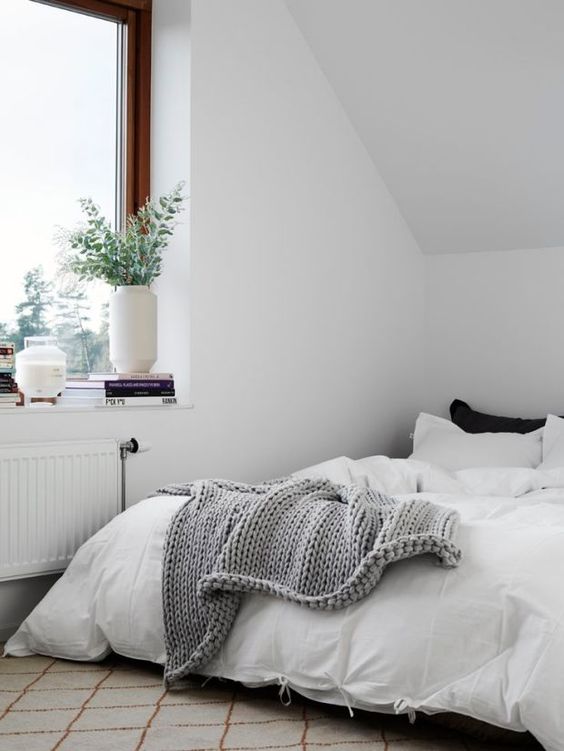 Ein minimalistisches Dachboden-Schlafzimmer in gemischten neutralen Farben, with touches of black