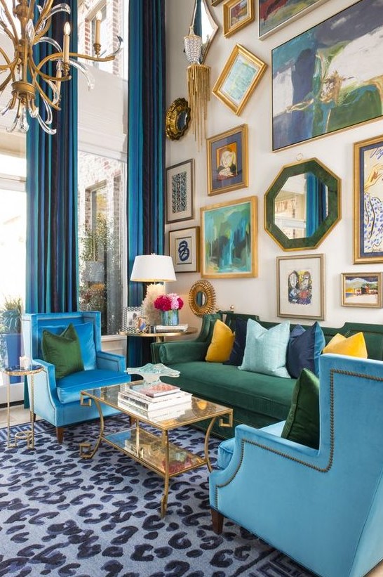 a colorful maximalist living room with double height ceilings, a neutral floor with a printed rug, blue and green furniture, a bold gallery wall