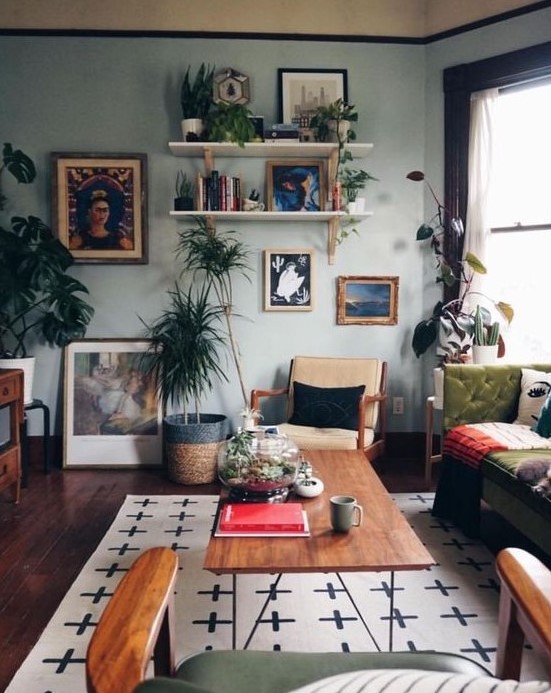 an eclectic living room with a gallery wall, open shelves, light blue walls, vintage furniture and potted greenery