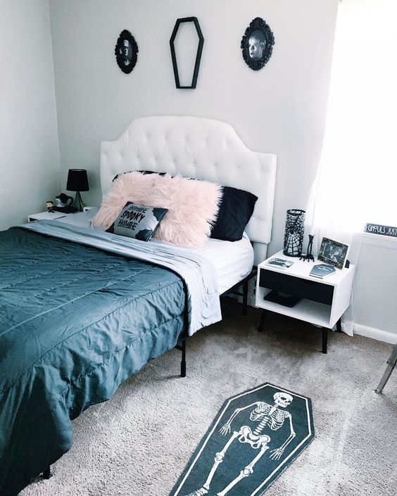 a glam Halloween bedroom with pretty photos, a coffin silhouette, a coffin and a skeleton rug and black and pink pillows