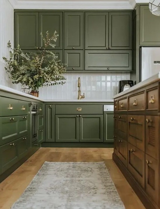 https://www.digsdigs.com/photos/2020/03/a-chic-olive-green-farmhouse-kitchen-with-shaker-cabinets-a-white-tile-backsplash-a-dark-stained-kitchen-island-and-a-printed-rug.jpg