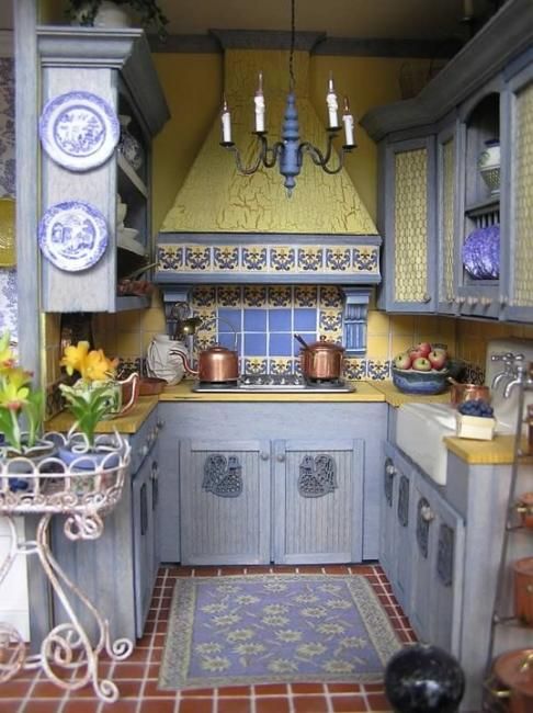 https://www.digsdigs.com/photos/2020/04/a-vintage-kitchen-with-light-blue-cabinets-bright-yellow-surfaces-and-mosaic-tiles-and-plates-with-yellow-and-blue.jpg