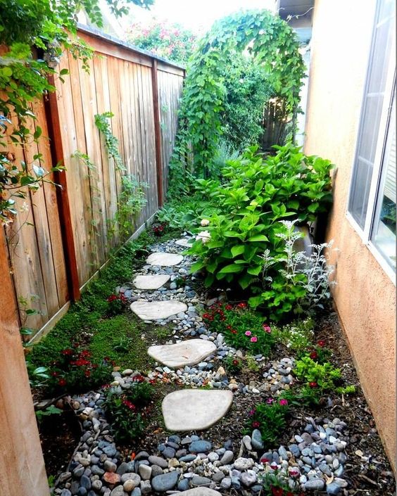 بالصور افكار بسيطة مميزة لتزيين حديقة المنزل حصري 2020 A-small-and-bright-garden-nook-with-pebbles-greeneyr-and-bright-blooms-shrubs-and-a-climbing-plants-on-the-fence