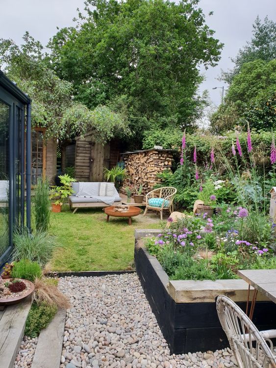 بالصور افكار بسيطة مميزة لتزيين حديقة المنزل حصري 2020 A-small-and-cozy-garden-with-a-flower-bed-some-bright-blooms-in-pots-and-not-only-a-lawn-and-some-garden-furniture