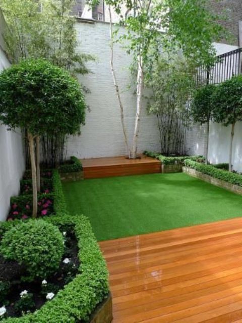 بالصور افكار بسيطة مميزة لتزيين حديقة المنزل حصري 2020 A-small-and-elegant-garden-with-a-green-lawn-with-some-flower-beds-with-blooms-and-greenery-and-shrubs-and-trees