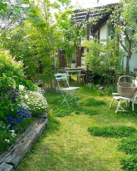 بالصور افكار بسيطة مميزة لتزيين حديقة المنزل حصري 2020 A-small-garden-with-a-lawn-a-flower-bed-with-bright-blooms-some-vintage-garden-furniture-and-some-shrubs-and-trees