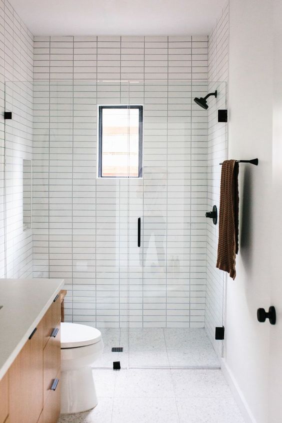 https://www.digsdigs.com/photos/2020/05/a-small-minimalist-bathroom-with-neutral-tiles-with-skinny-ones-and-printed-ones-on-the-floor-a-small-window-and-black-fixtures-for-a-modern-feel.jpg