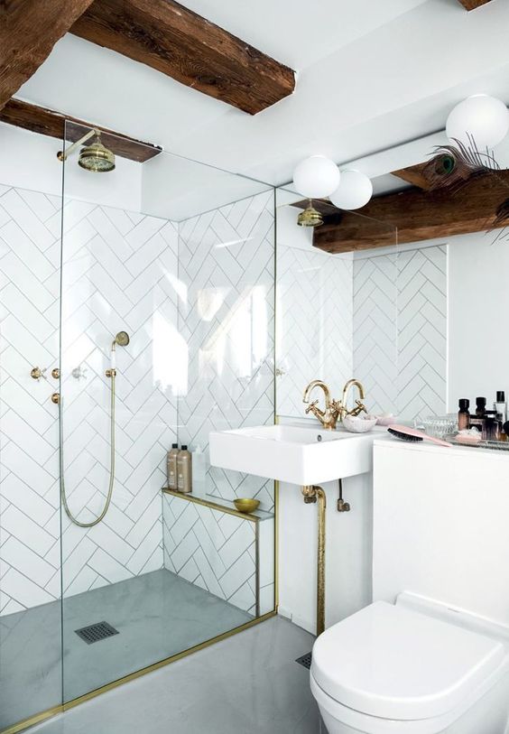 https://www.digsdigs.com/photos/2020/05/a-small-yet-cool-bathroom-with-white-herrignbone-tiles-dark-wooden-beams-gold-fixtures-for-a-luxurious-touch.jpg