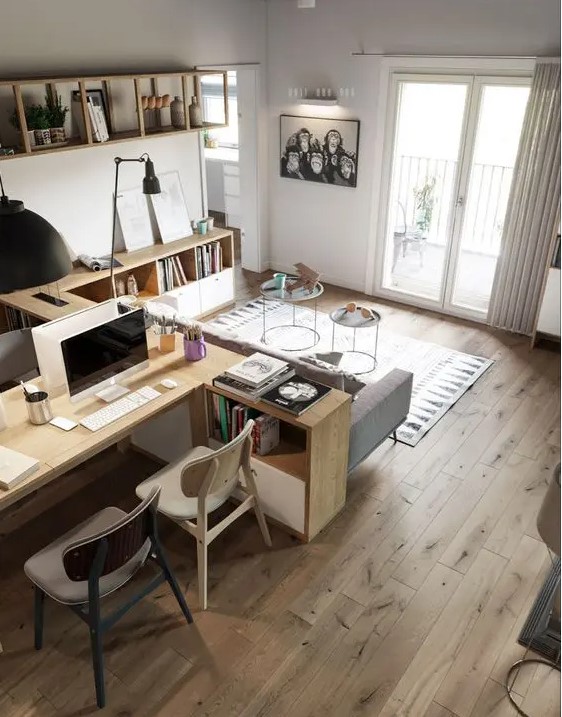 an airy Scandinavian living room with a corner bookshelf, a grey sofa, coffee tables, a desk, some lamps and a printed rug