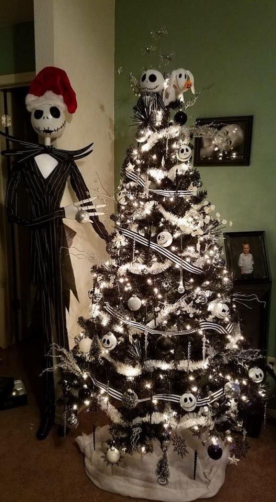 Beside it, Jack Skellington stands with black and white Skellington decorations, illuminations, white festoons, and black and white bows adorning a black Christmas tree.