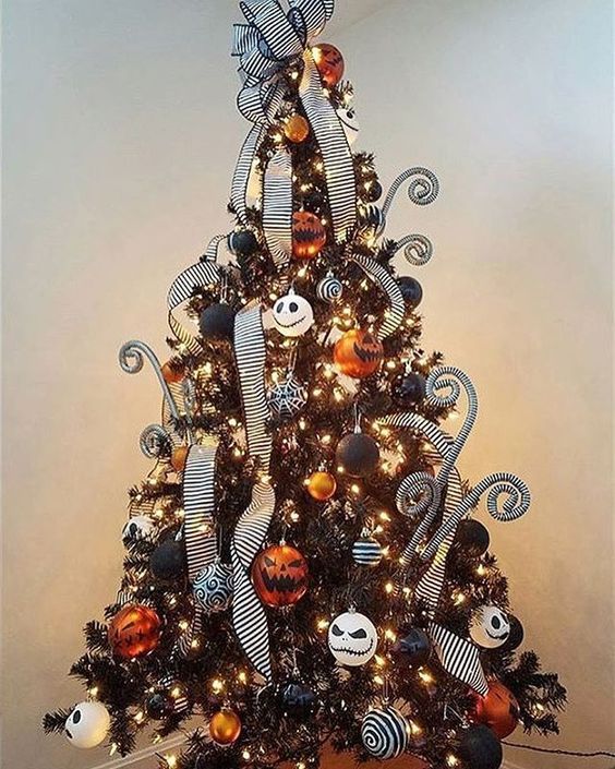 A dark Christmas tree with lights, orange, dark and white decorations and Jack Skellington ones, striped ribbons and curls.