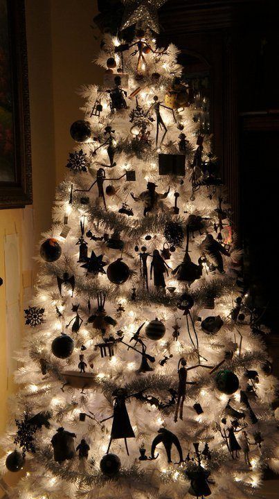 A beautifully illuminated white Christmas tree adorned with Nightmare Before Christmas decorations and garlands is a delightful concept.