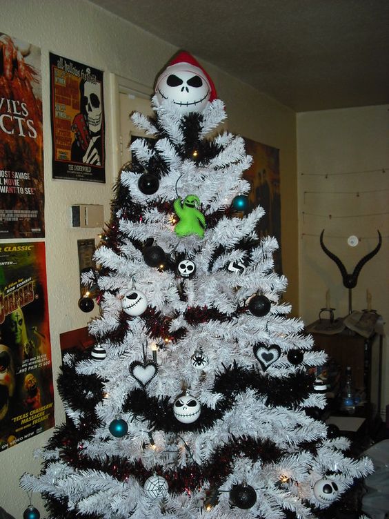 A snowy Christmas tree with dark garlands, monochrome decorations, Jack Skellington ones and a Jack Skellington topper.
