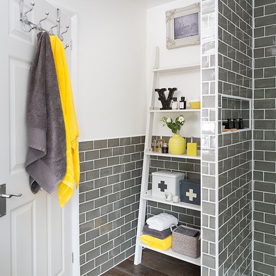 A Bathroom Clad With Grey Tiles With White Furniture And Grey And Yellow Accessories And Accents Looks Very Bold 