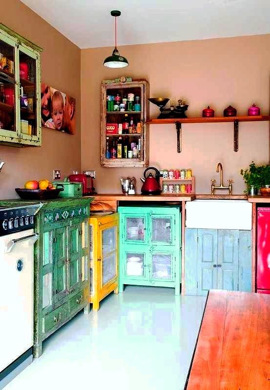 مطبخ بوهو الحد الأقصى مع جدران وردية مغبرة وخزائن ملونة غير متطابقة وأدوات طهي ملونة أمر مذهل