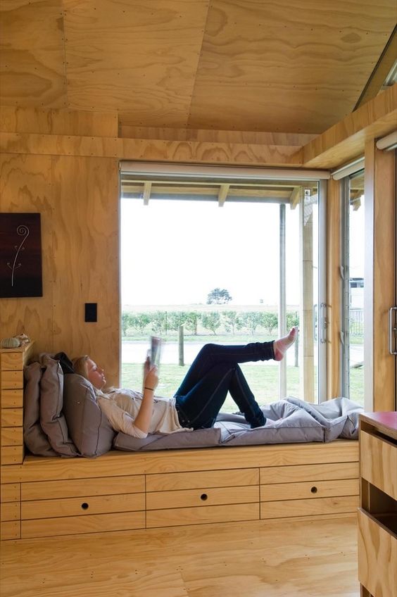 a corner window with a windowsill daybed, with storage drawers is a very cozy and lovely space with cool views and much natural light