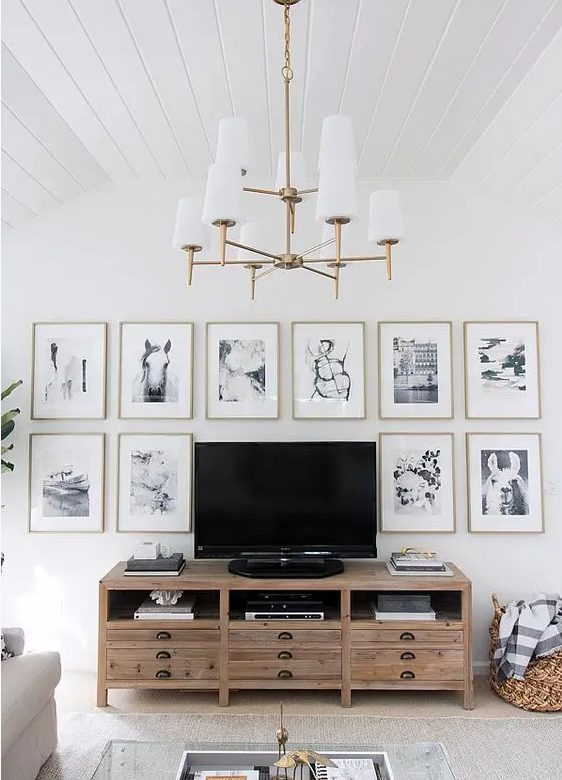 https://www.digsdigs.com/photos/2021/11/a-chic-gallery-wall-with-thin-gold-frames-white-matting-and-black-and-white-photos-framing-the-TV-is-cool.jpg