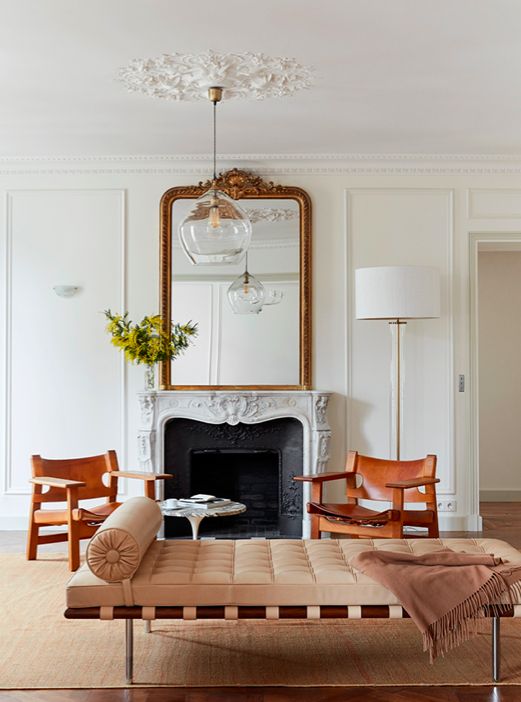 غرفة معيشة باريسية أنيقة رائعة مع نقش تاج مزخرف وميدالية سقف ، مع مدفأة لا تعمل ، وأريكة أنيقة وكراسي جلدية