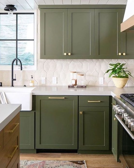المطبخ الأخضر الجذاب مع بلاط أبيض مائل للخلف ولمسات ذهبية بالإضافة إلى تركيبات سوداء أنيقة للغاية