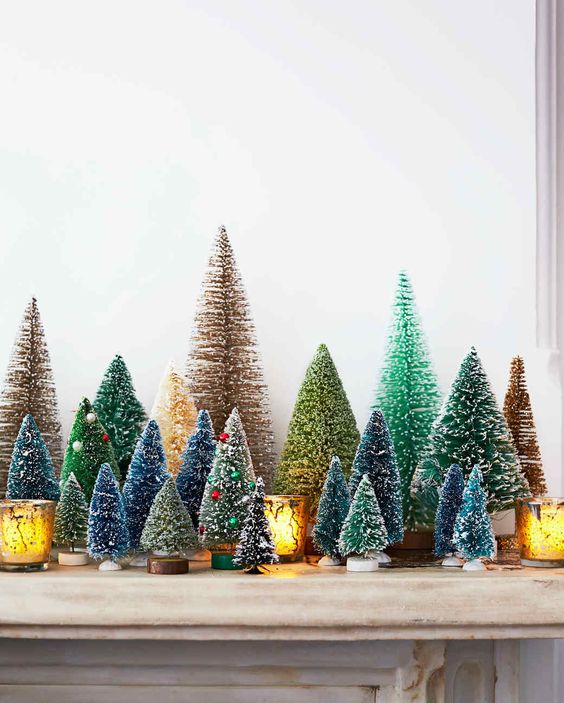 رف عتيق بزجاجة ملونة بفرشاة أشجار عيد الميلاد مع حبات زاهية مثل الحلي وحاملات الشموع