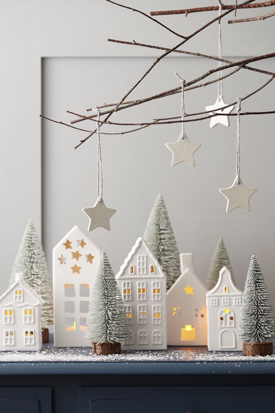 https://www.digsdigs.com/photos/2021/12/25-a-Scandinavian-arrangement-with-white-house-candleholders-mini-bottle-brush-trees-and-white-clay-stars-over-it.jpg